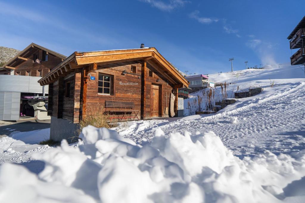 a log cabin in the snow with a pile of snow at Rumpelstilzchen in Bettmeralp