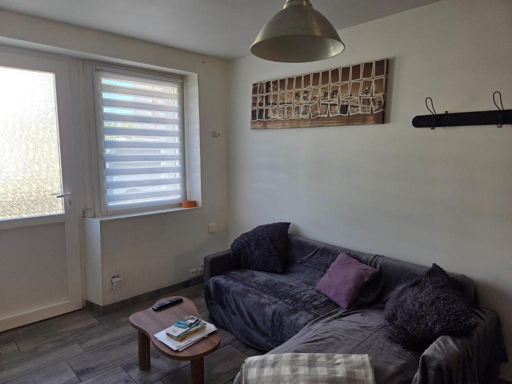 a living room with a couch and a window at comfortable village house in Le Fossat