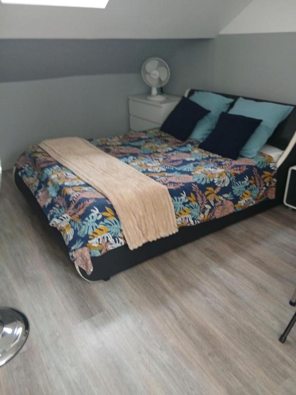 a bedroom with a bed with a quilt on it at Le Trait d'union - Studio César, 2éme Étage in Romilly-sur-Seine