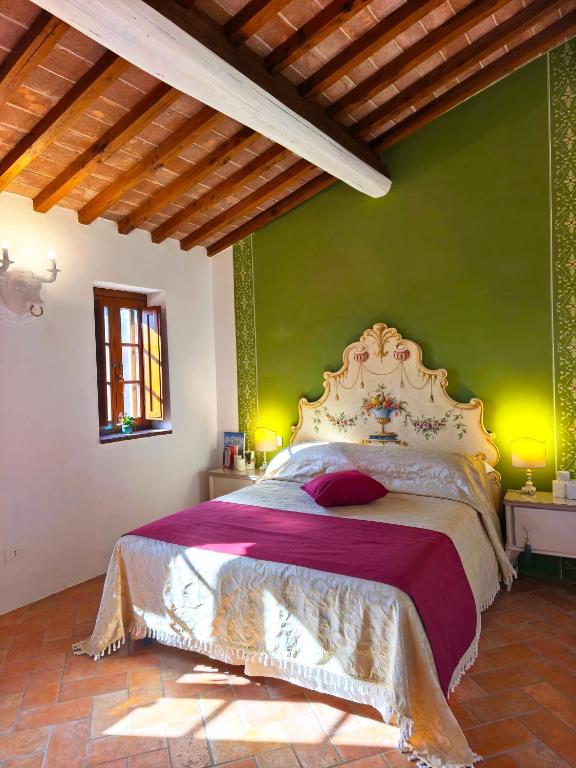 a bedroom with a large bed with a green wall at Dimora del Passaggio in Castiglion Fiorentino