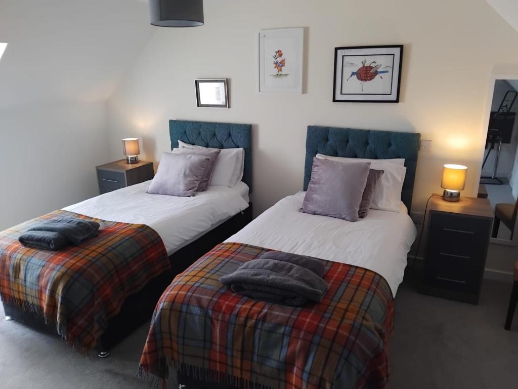 two beds sitting next to each other in a bedroom at The Station Hotel Insch in Insch
