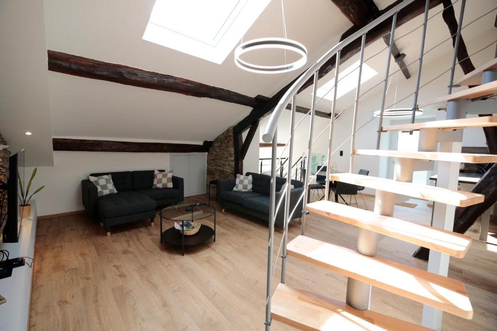 a living room with a staircase in a loft at Maison Camélia in Paliseul