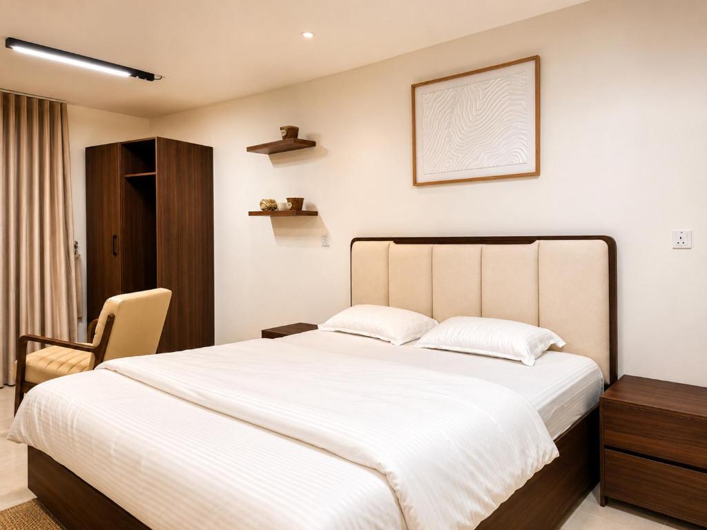 a bedroom with a large white bed and a chair at Alsharafh room 3 in Sayq