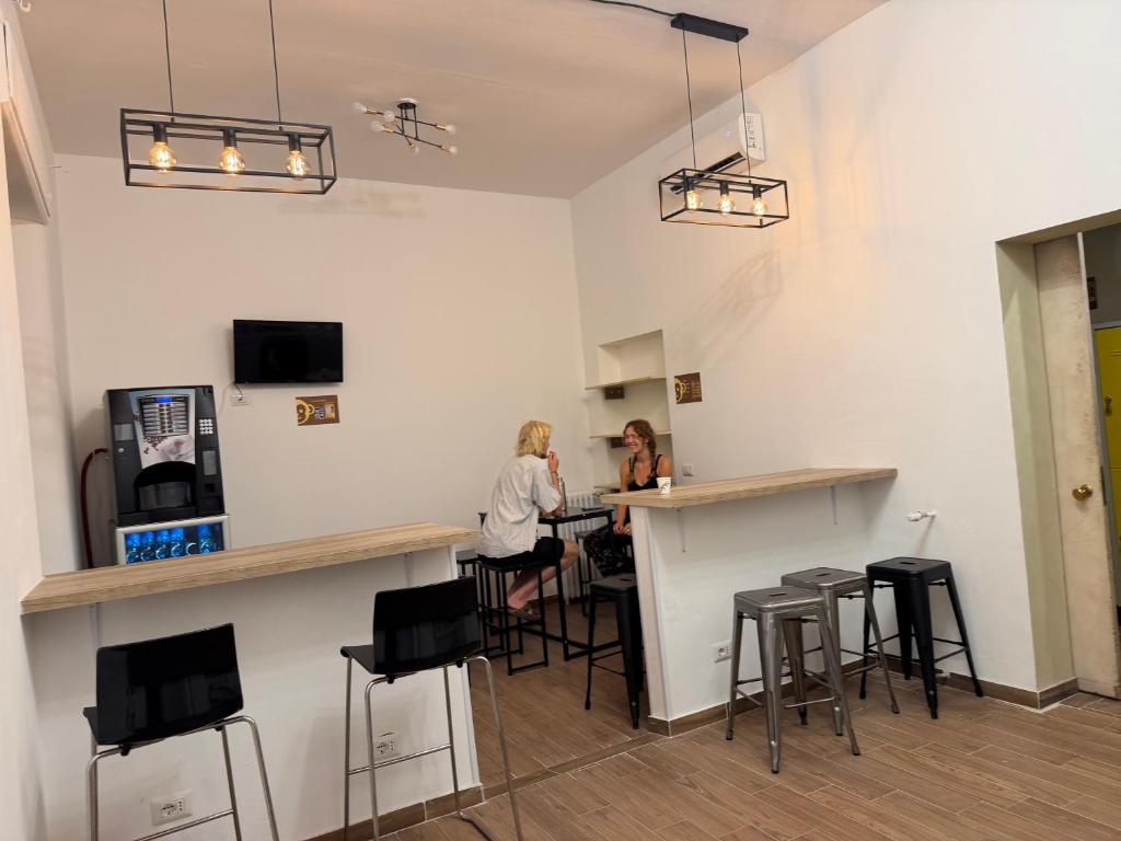two women sitting at a bar in a room at Monkey Hostel Milano in Milan