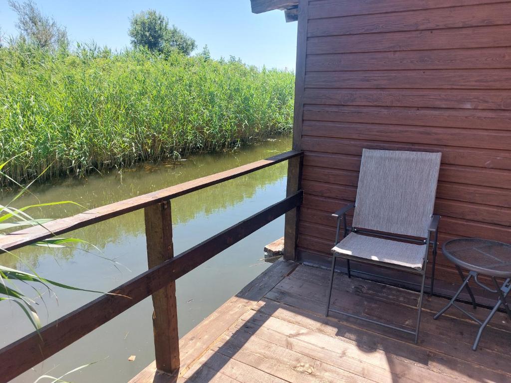 a chair and a table on a deck next to water at Apartman Dva Dječaka in Ulcinj