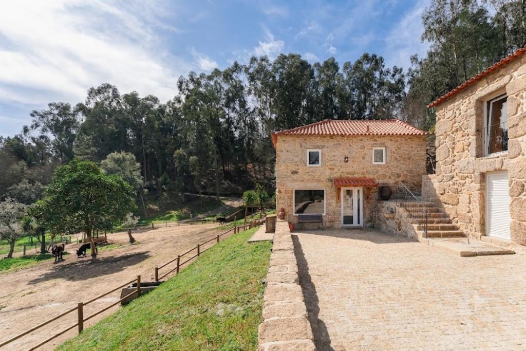 a large stone building with a fence next to it at Banduja Reserve - Slow by nature in Celorico de Basto