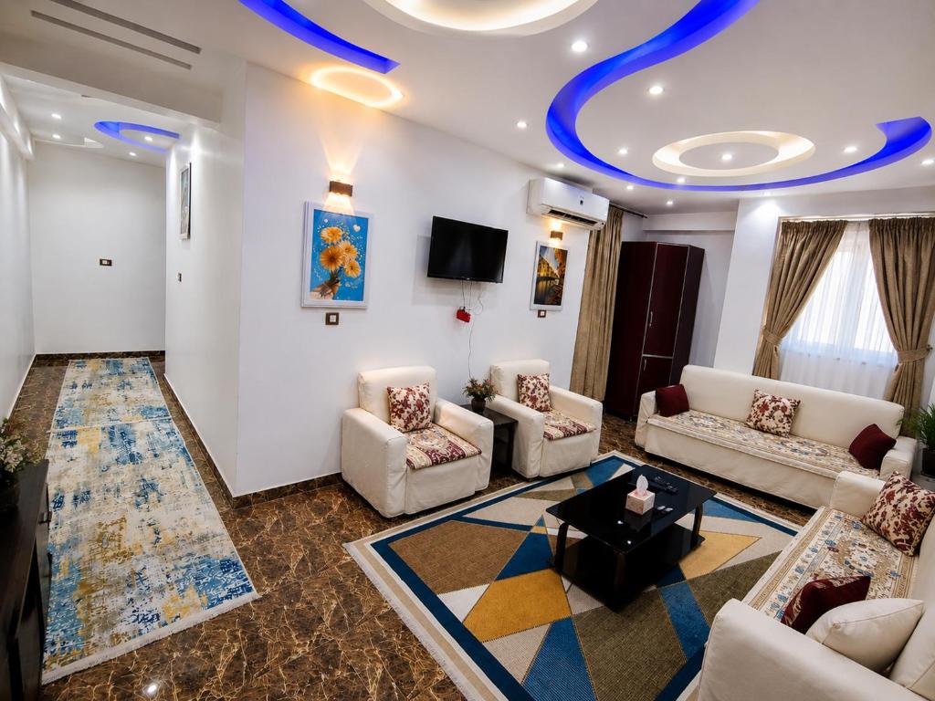 a living room with couches and a tv at شقة مميزة بجوار كورنيش النيل اسوان - عائلات فقط in Aswan