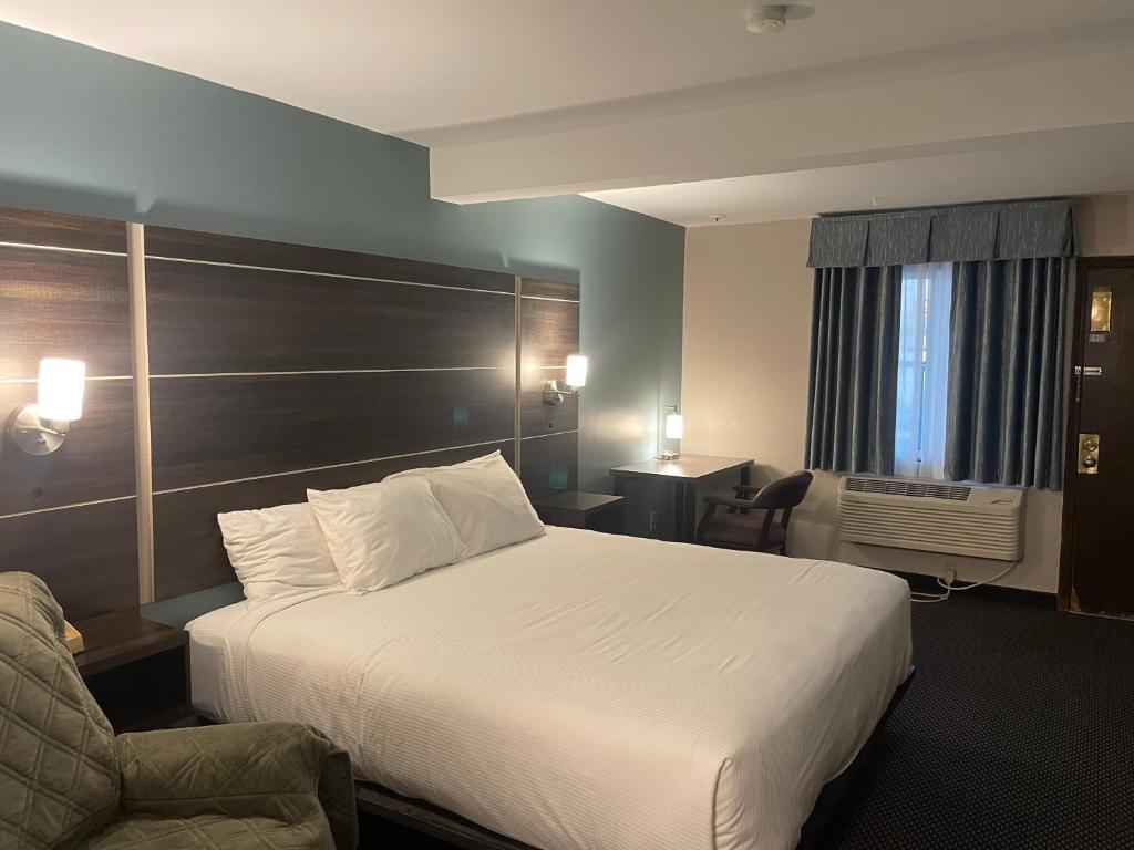 a hotel room with a bed and a chair at Landmark Inn in Osawatomie