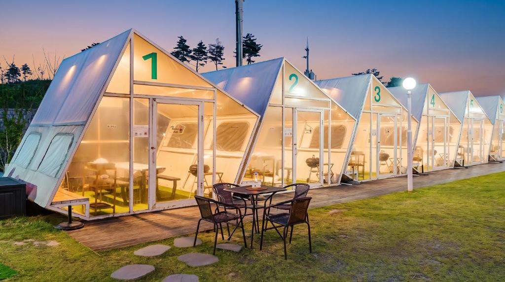 a row of domes with a table and chairs in front at Sokcho Night Sky Pension in Sokcho