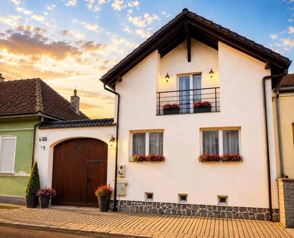 a white house with flower boxes on the windows at Margareta's House - Free Parking, Garden, Near Sibiu in Sibiu
