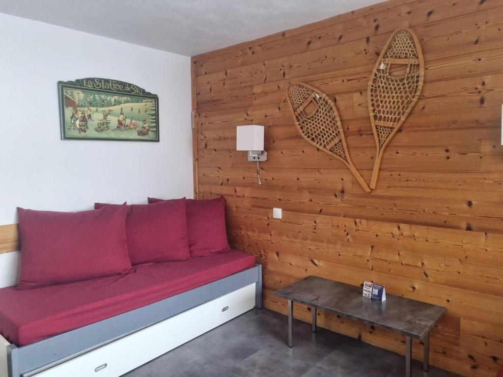 a red couch in a room with a wooden wall at Appartement 2 pièces rénové 5 pers. au cœur des pistes - FR-1-181-952 in Plagne Bellecote