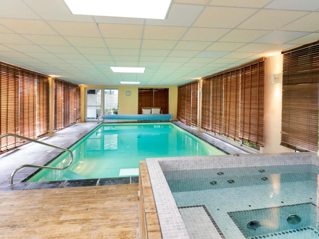 a large swimming pool in a building at ibis Styles Morlaix in Morlaix
