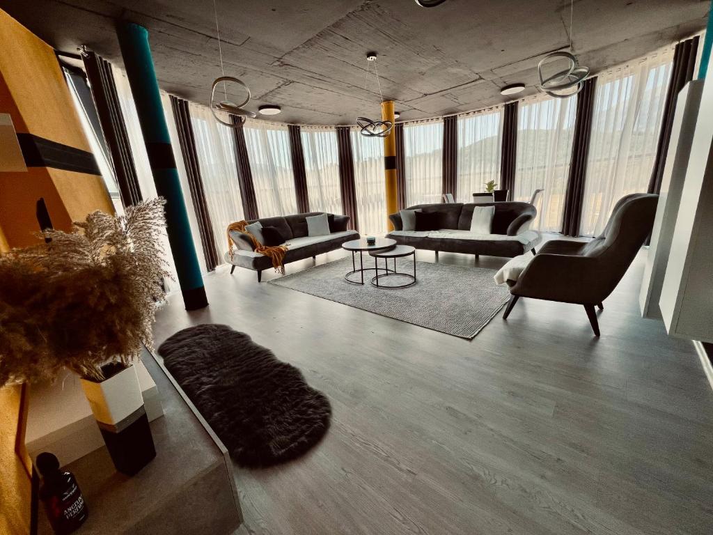 a living room with couches and chairs and a table at L&A Apartments in Dragash