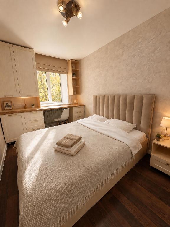a bedroom with a large bed with two towels on it at Люкс в центре Караганды in Karagandy