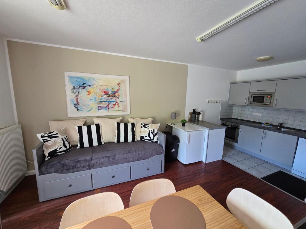 a living room with a bed and a kitchen at Ferienwohnung Ohechaussee in Norderstedt