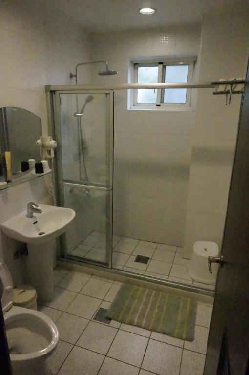 Un baño con ducha, inodoro y lavabo. en Dong Hua Dream House, en Pinghe