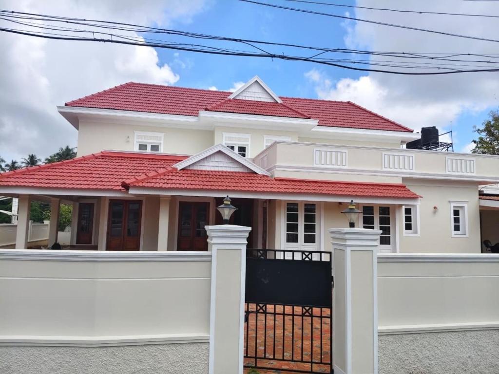 a white house with a red roof at Sky Villa in Trichūr