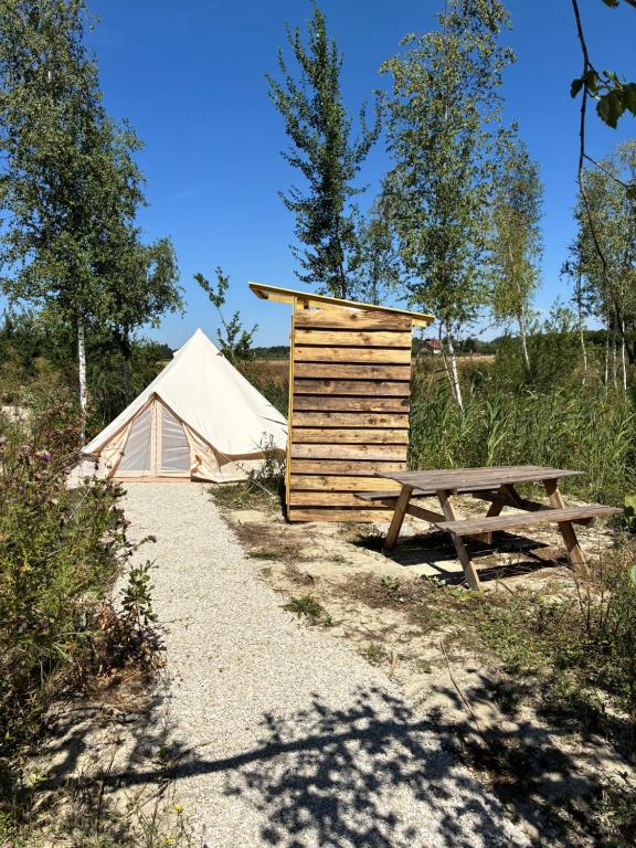 a tent and a picnic table and a bench at Tipi du pied de loup in Clérey