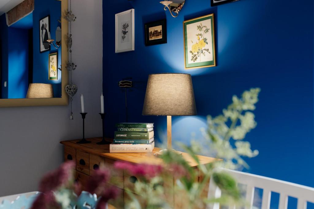 a lamp on a table in a room with blue walls at Leśniczówka Dobrocin in Małdyty