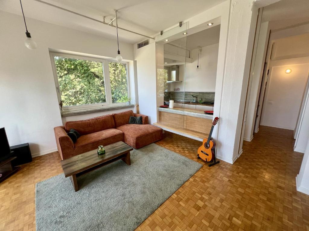 a living room with a couch and a guitar at Sea Breeze - Barcola - Trieste Reception in Trieste