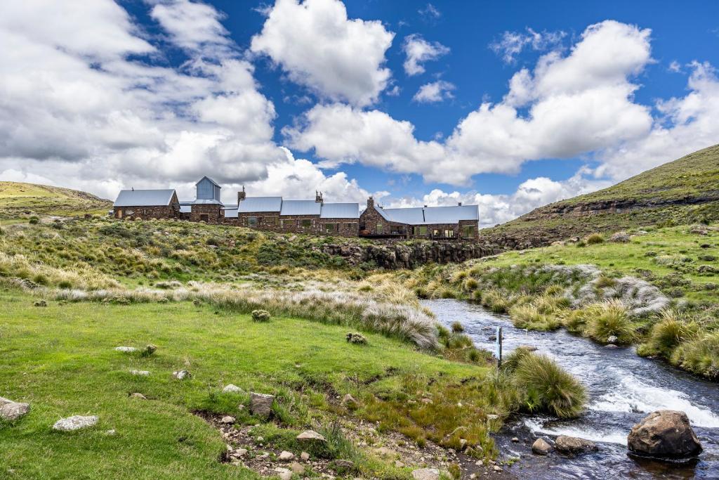 a house on the side of a hill next to a river at Tenahead Lodge & Spa in Rhodes
