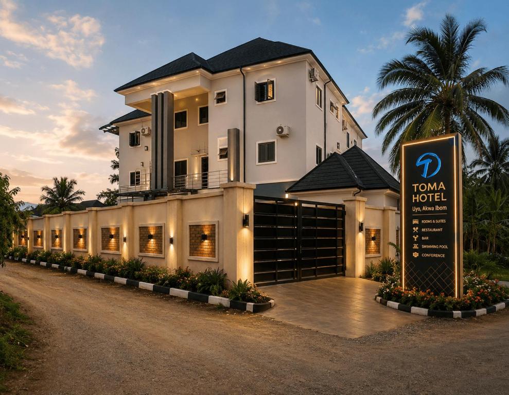 un hotel con un'insegna davanti a un edificio di TOMA Hotel a Uyo