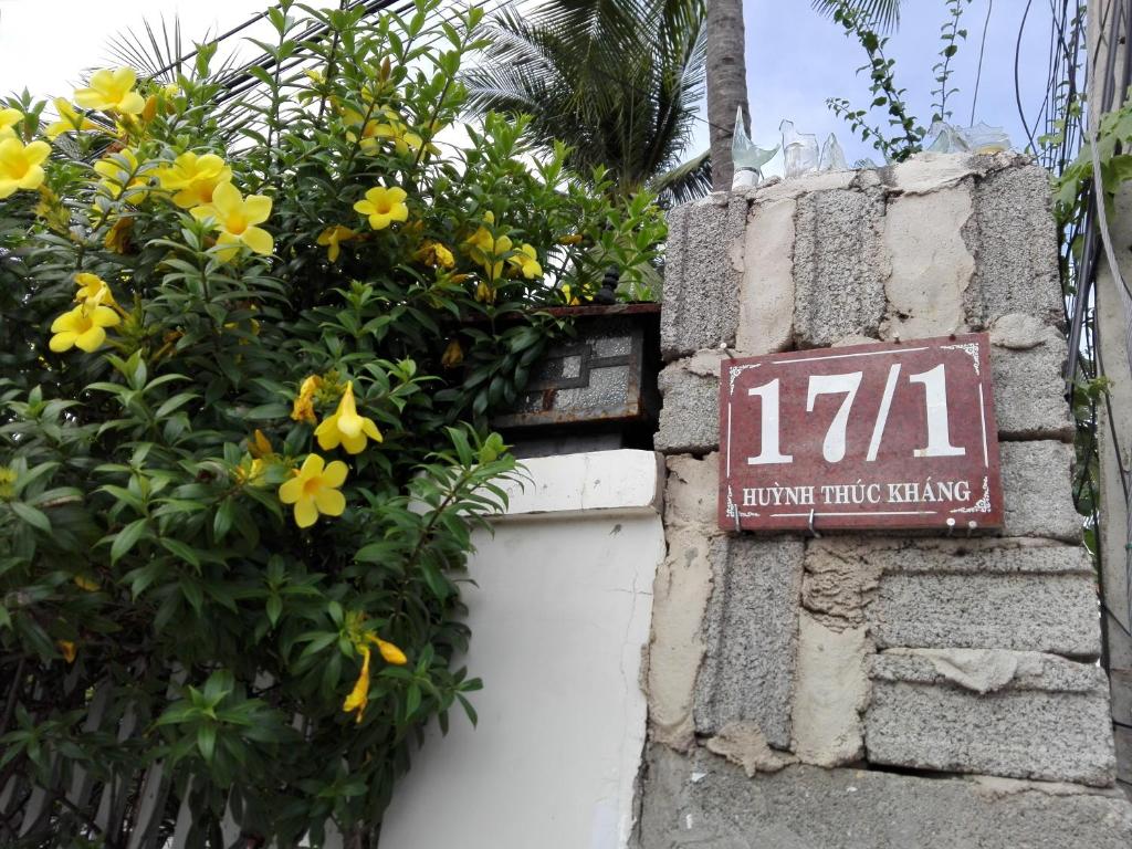 a sign on the side of a building with yellow flowers at The House 17/1 in Mui Ne