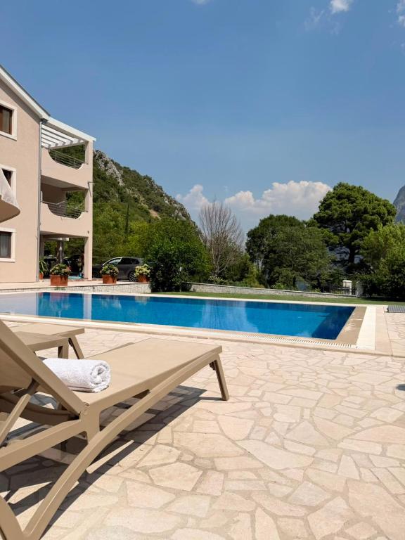 a view of a swimming pool with a table and a chair at Milas Trojica Kotor in Kotor