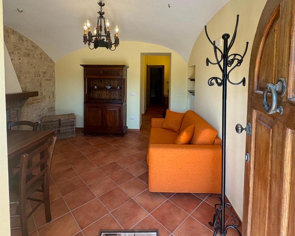 a living room with an orange couch and a kitchen at La Sorgente Alta in Rocchetta a Volturno