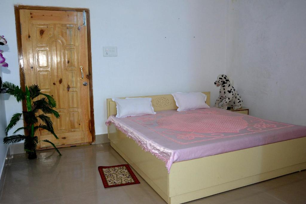 a bedroom with a bed and a door and a dog at BBL Resort in Bokākhāt