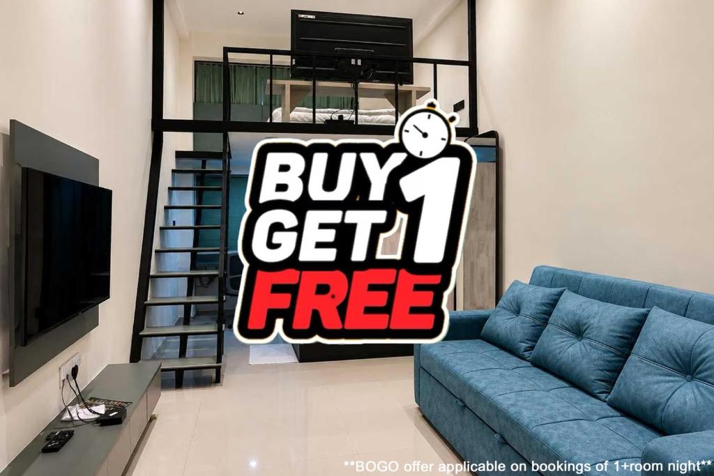 a living room with a blue couch with a buy get free sign at Collection O Airport Road Formerly Hotel Nano Pod in Surat