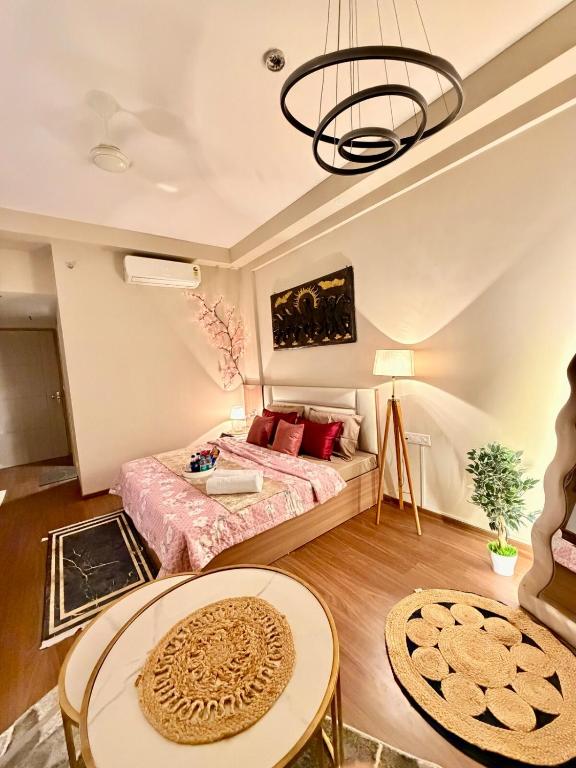 a room with a bed and a table in it at R&R Eleanor Suites in Greater Noida