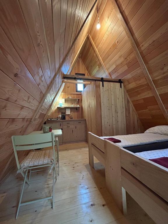 a room with a bed and a table in a attic at Glamping cabins in Gorenja Vas