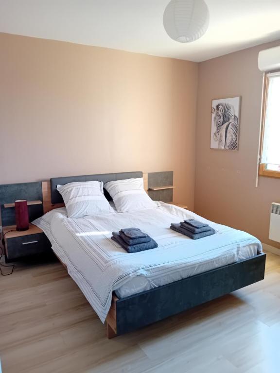 a bedroom with a large bed with white sheets at Le Cottage d'Aubigny in Aubigny-sur-Nère