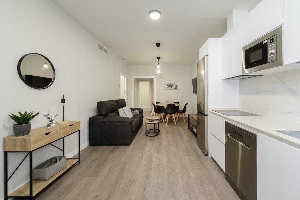 a kitchen and living room with a couch and a table at Torrejón Suites 2 in Torrejón de Ardoz