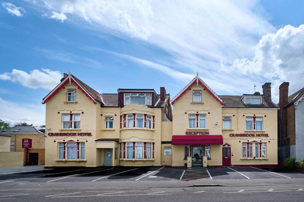 a large yellow building with a red roof at Cranbrook Hotel in Ilford