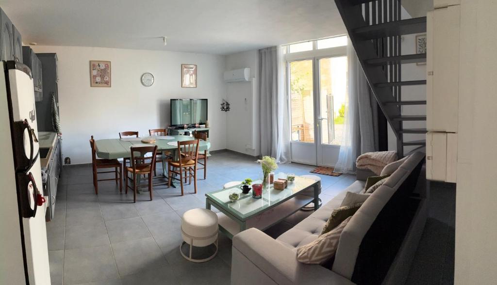 a living room with a couch and a table at Maison « La grange » climatisée in Azay-le-Rideau