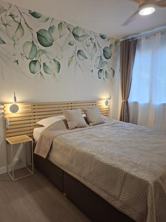 a bedroom with a bed with a flower mural on the wall at Hôtel Montespan in Lussac-les-Châteaux