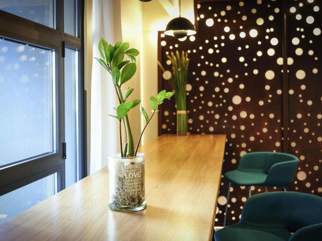 a vase with a plant sitting on top of a table at Mercure Perpignan Centre in Perpignan