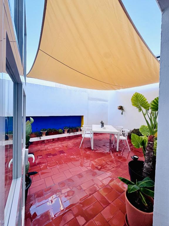 a patio with a white table and some plants at Casa Miguel - Apartamento 4 in Sanlúcar de Barrameda