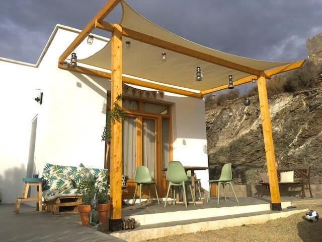 a pavilion with chairs and a table in front of a building at Casa luz Vista Verde Appartment in Polopos