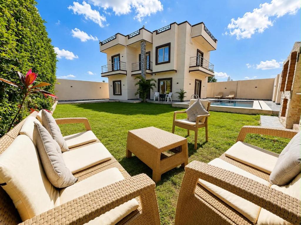 a backyard with furniture and a house at La Dolce Villa with Private Pool in Borg El Arab