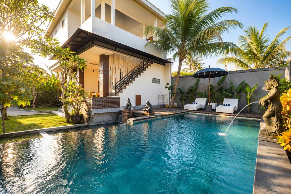 a villa with a swimming pool in front of a house at Liam Private Villa in Ubud