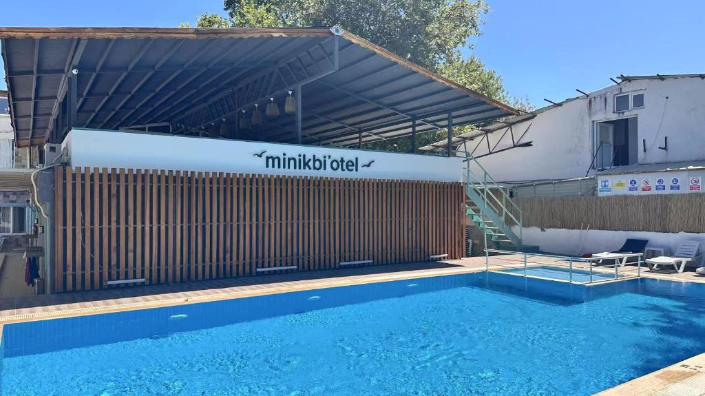a swimming pool in front of a building at Minikbiotel in Erdek