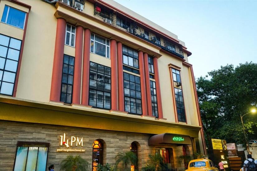 a building with a taxi parked in front of it at Middleton Inn in Kolkata