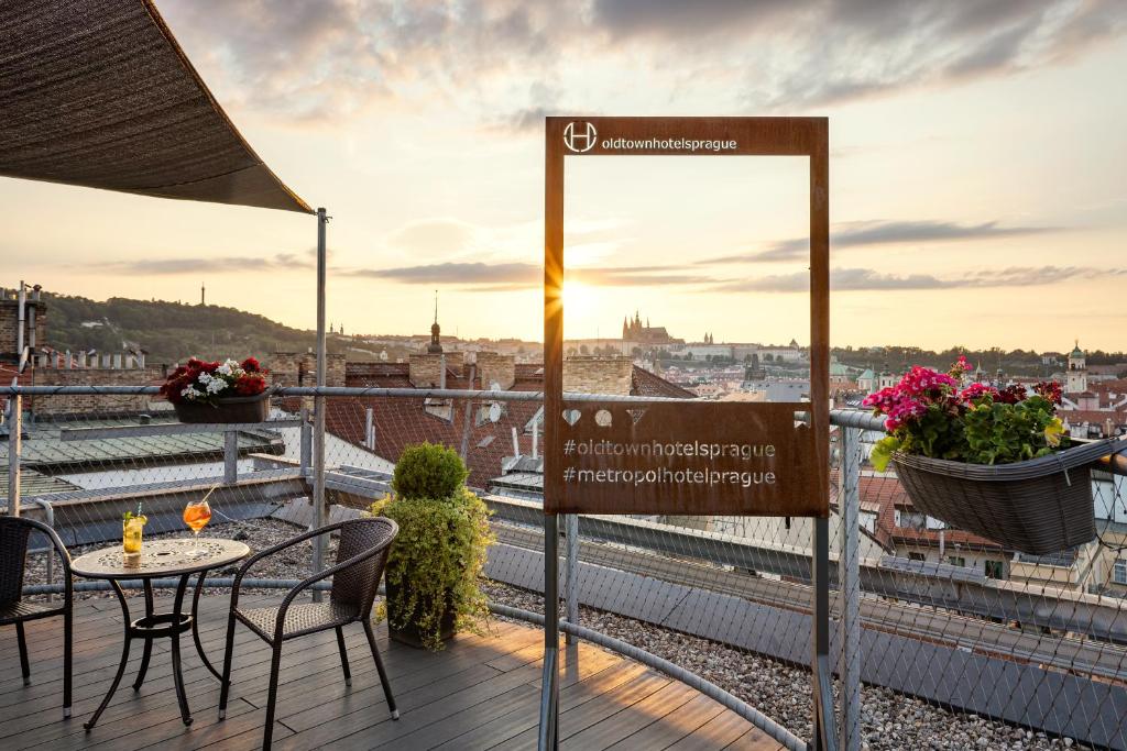 a balcony with a table and chairs and a view of the city at Metropol Design Hotel Old Town in Prague