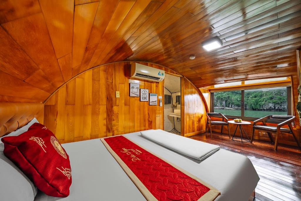a bed in a boat with a room with a table at Vietnam Venture Cruises in Cat Ba