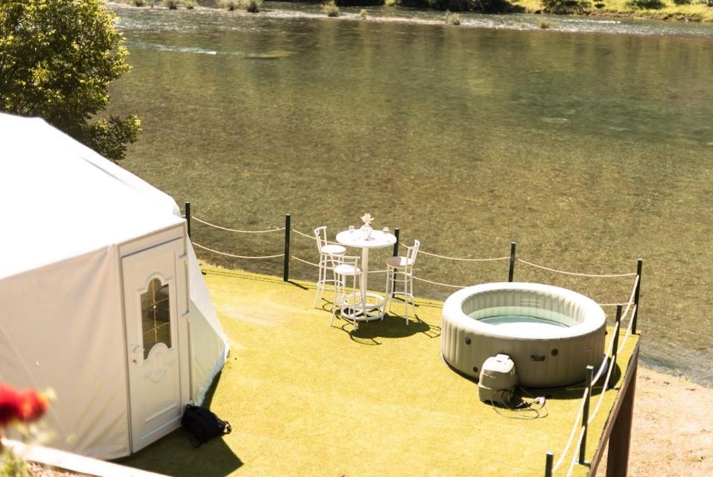 a boat with a tub on the side of the water at Drivibe Glamping, Goražde in Goražde