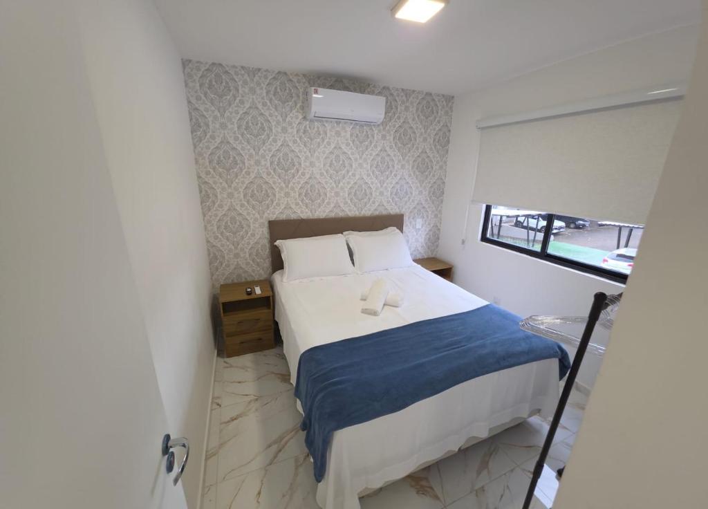 a bedroom with a bed with two towels on it at Apartamento Crisalidas em Foz in Foz do Iguaçu