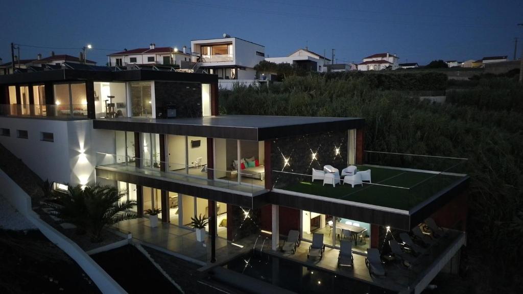 a large house with a lot of windows at night at Mycelio Atlantic Residence with Atlantic View in Ribamar